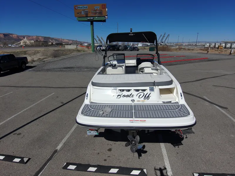 Slide: The Image of 2017 Bayliner VR6 boat parked in a lot, rear view with "Boots Off" text. - 12
