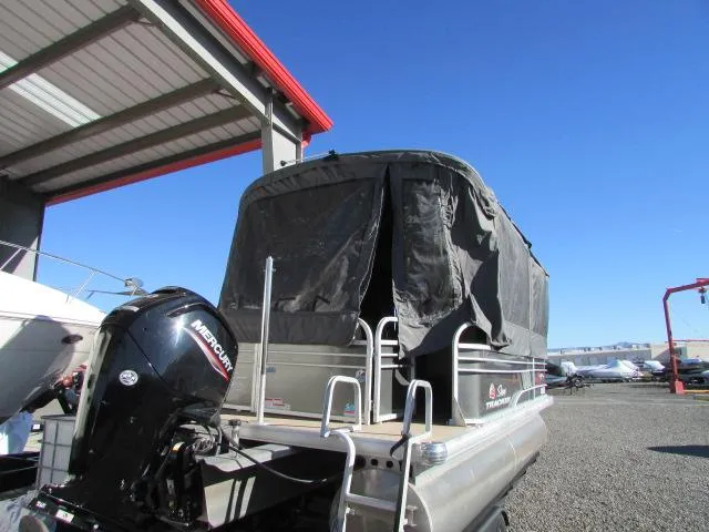 Slide: The Image of 2021 Sun Tracker Party Barge 20 DLX pontoon boat with Mercury engine, covered and parked outdoors. - 5