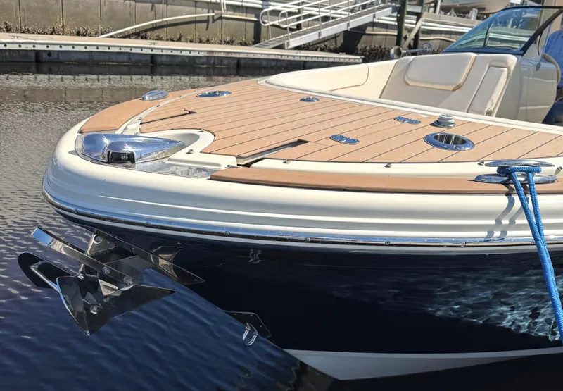 Slide: The Image of 2023 Chris-Craft Launch 28 GT boat docked, showcasing elegant design and teak deck. - 2