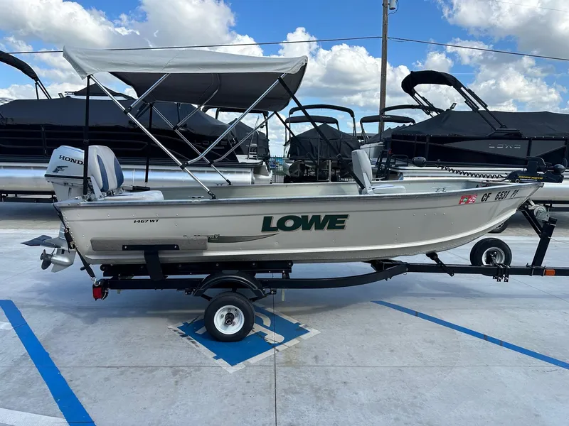 Slide: The Image of 2003 Lowe 1467 Sea Nymph boat on trailer, with canopy and Honda motor. - 11