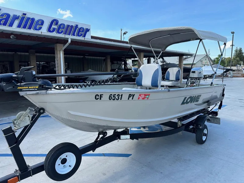 Slide: The Image of 2003 Lowe 1467 Sea Nymph boat with canopy on trailer at Marine Center. - 2