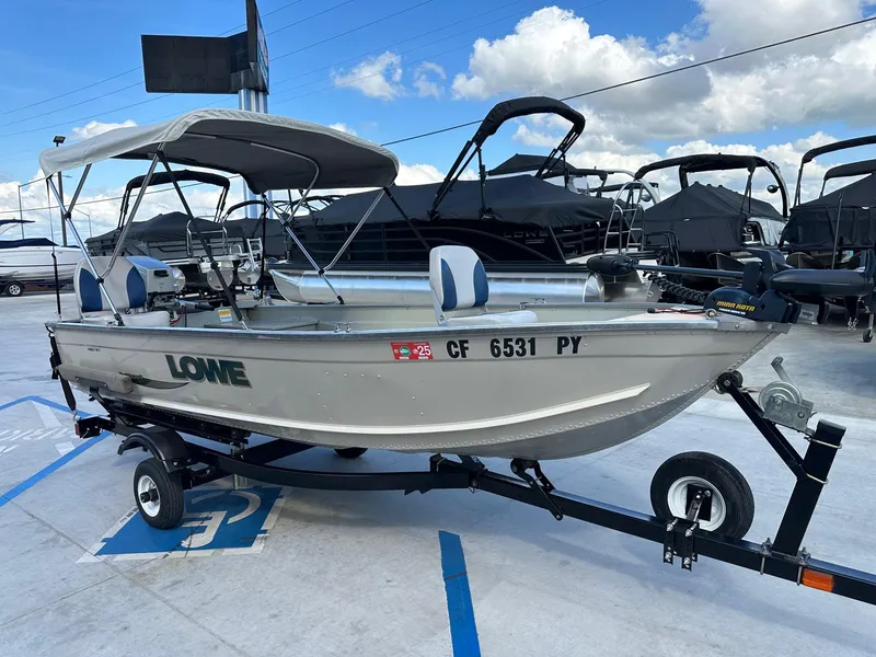 Slide: The Image of 2003 Lowe 1467 Sea Nymph boat on trailer, parked outdoors under a cloudy sky. - 3