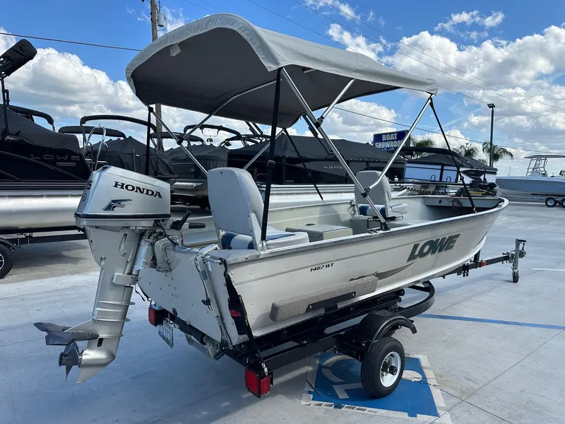 Slide: The Image of 2003 Lowe 1467 Sea Nymph boat with Honda motor on trailer, parked outdoors. - 4