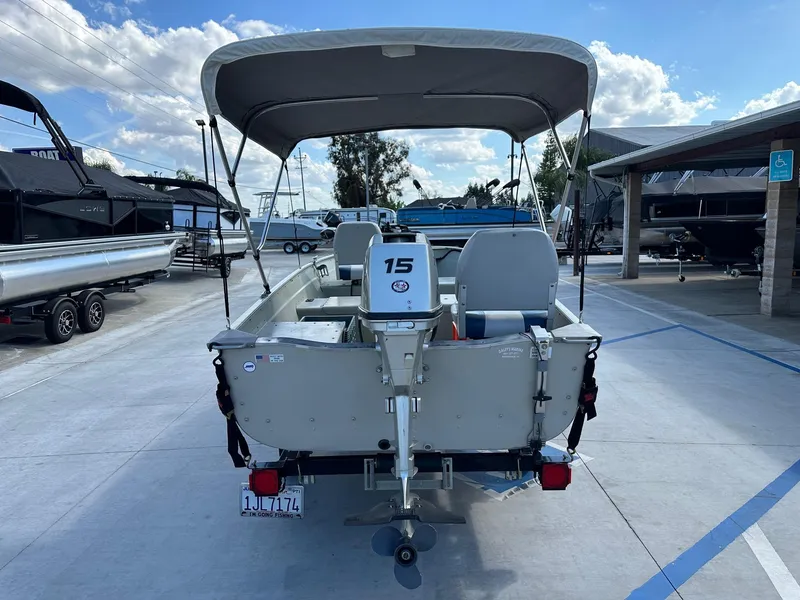 Slide: The Image of 2003 Lowe 1467 Sea Nymph boat with canopy and motor, parked at a marina. - 5