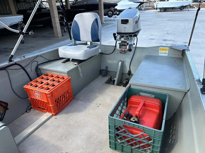 Slide: The Image of 2003 Lowe 1467 Sea Nymph boat interior with motor, crates, and seating. - 8