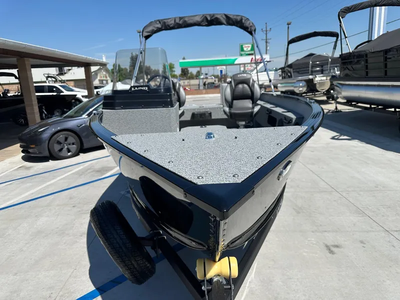 Slide: The Image of 2025 Lund Adventure 1675 SS boat with 90HP Mercury engine, parked outdoors. - 3