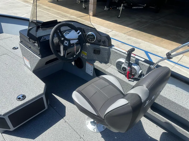 Slide: The Image of 2025 Lund Adventure 1675 SS boat interior with steering wheel and controls. - 5