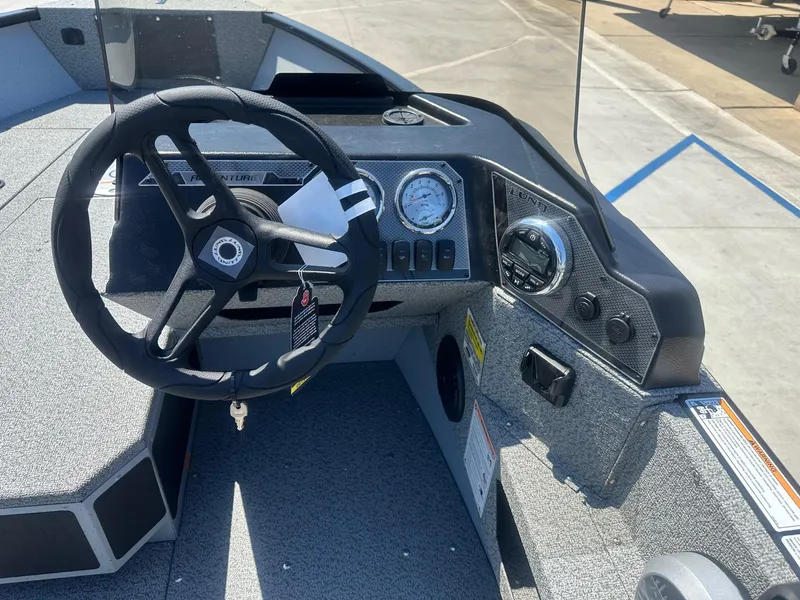 Slide: The Image of 2025 Lund Adventure 1675 SS boat dashboard with steering wheel and gauges. - 6