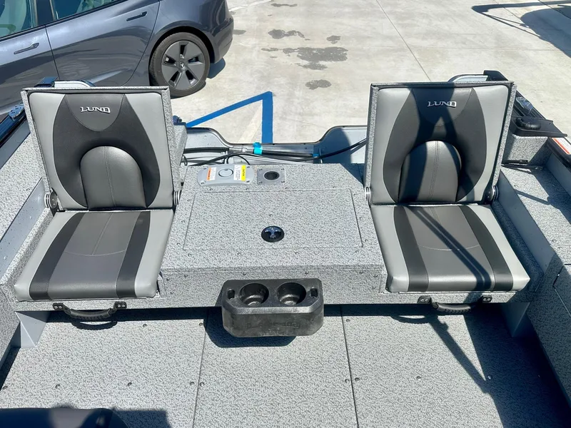 Slide: The Image of 2025 Lund Adventure 1675 SS boat interior with two gray seats and storage compartment. - 7