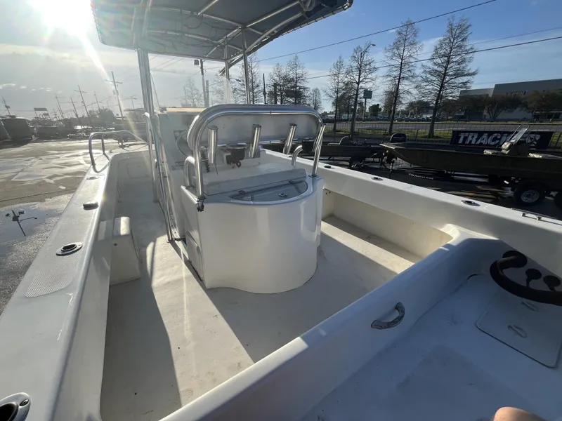 Slide: The Image of 2012 Twin Vee Ocean Cat 22 boat interior with console and seating, under sunny sky. - 13