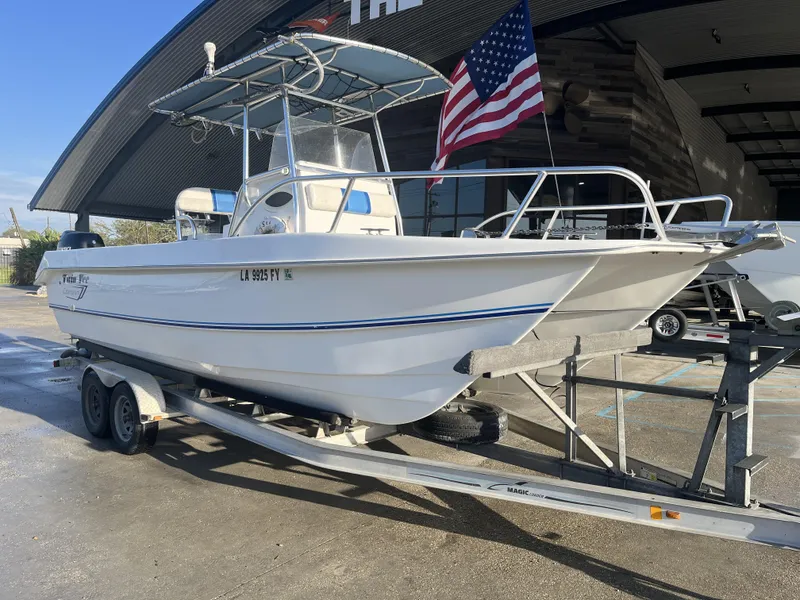 Slide: The Image of 2012 Twin Vee Ocean Cat 22 boat on trailer, American flag, outdoor setting. - 2