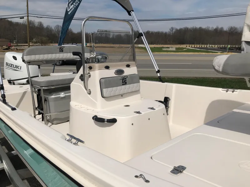 Slide: The Image of 2025 Carolina Skiff 178 JLS boat with Suzuki engine, parked outdoors. - 6