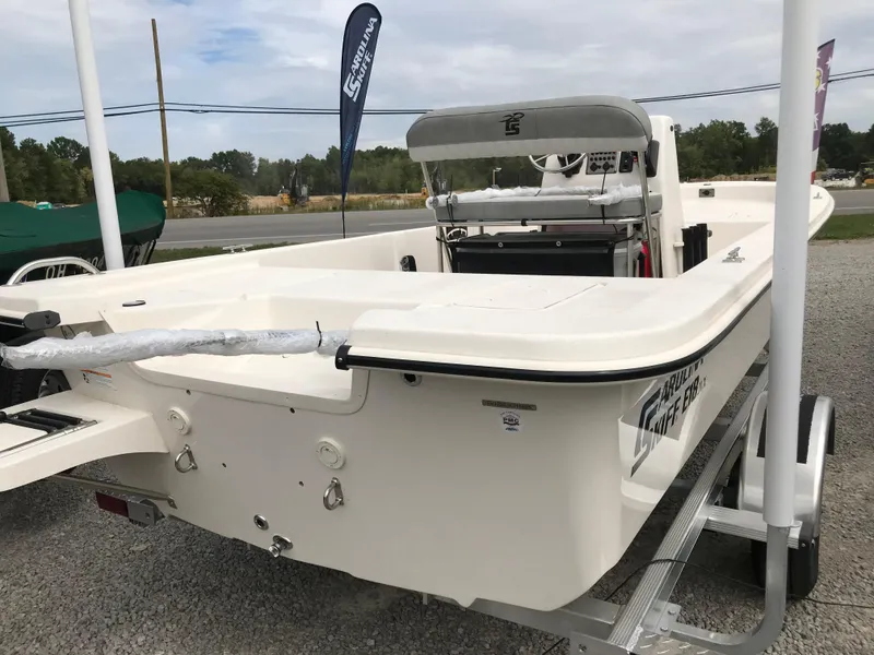 Slide: The Image of 2025 Carolina Skiff E18 JVX CC boat on trailer, displayed outdoors. - 11