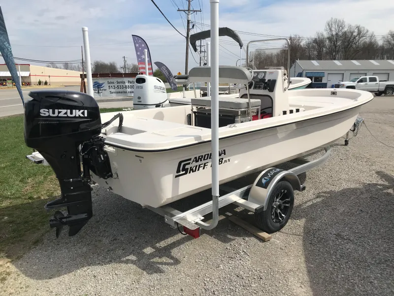 Slide: The Image of 2025 Carolina Skiff E18 JVX CC boat with Suzuki outboard motor on a trailer. - 3
