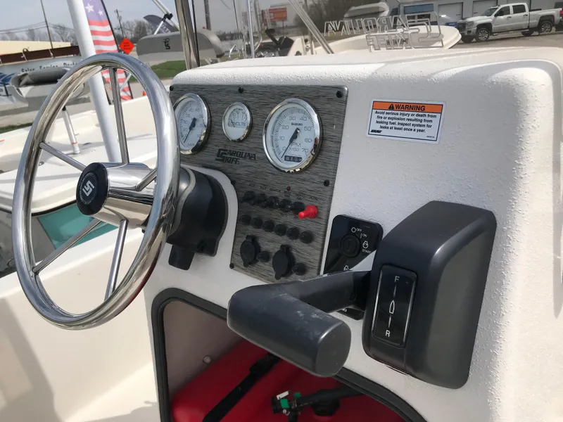 Slide: The Image of 2025 Carolina Skiff E18 JVX CC boat dashboard with steering wheel and control panel. - 4