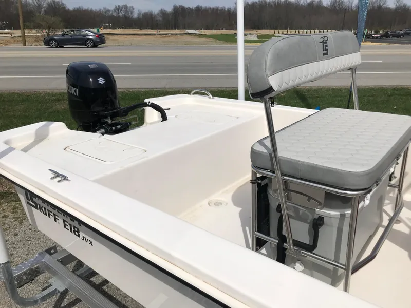 Slide: The Image of 2025 Carolina Skiff E18 JVX CC boat with Suzuki outboard motor, parked near a road. - 5