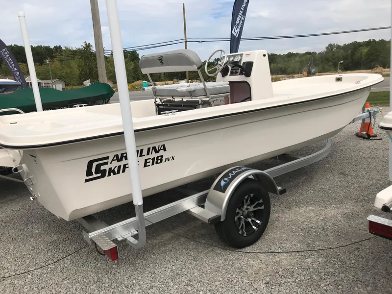 Slide: The Image of 2025 Carolina Skiff E18 JVX CC boat on trailer, displayed outdoors. - 9