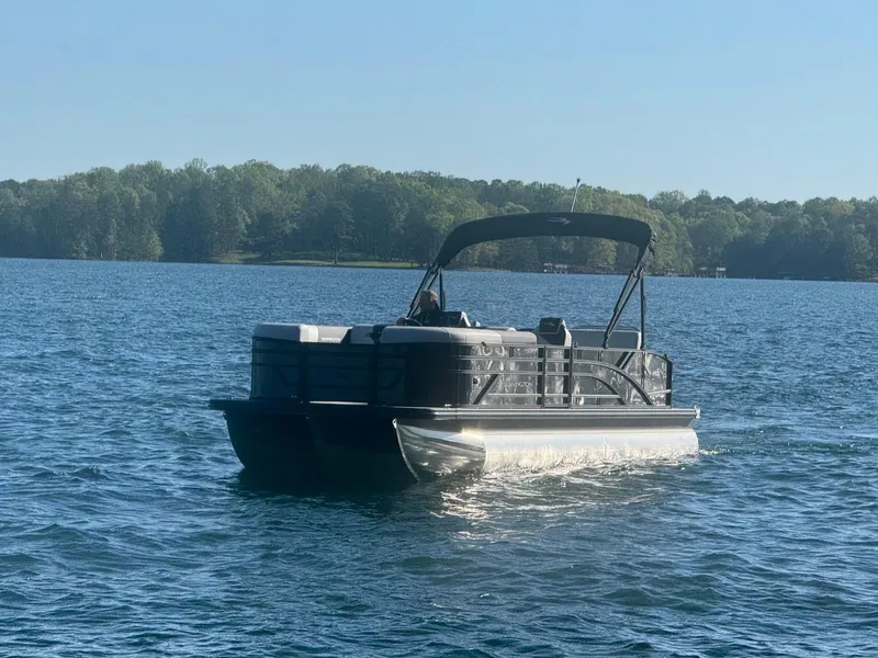 Slide: The Image of 2025 Bennington 22SSB pontoon boat cruising on a serene lake. - 3