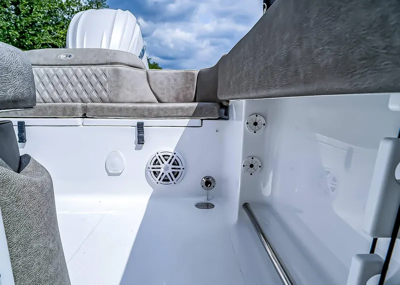 Slide: The Image of 2025 Sea Hunt Ultra 235 SE boat interior with cushioned seating and speaker system. - 13