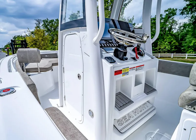 Slide: The Image of 2025 Sea Hunt Ultra 235 SE boat interior with steering console and seating. - 14