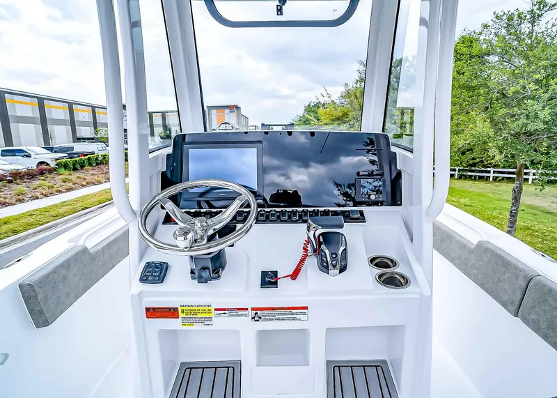 Slide: The Image of 2025 Sea Hunt Ultra 235 SE boat dashboard with steering wheel and navigation controls. - 16