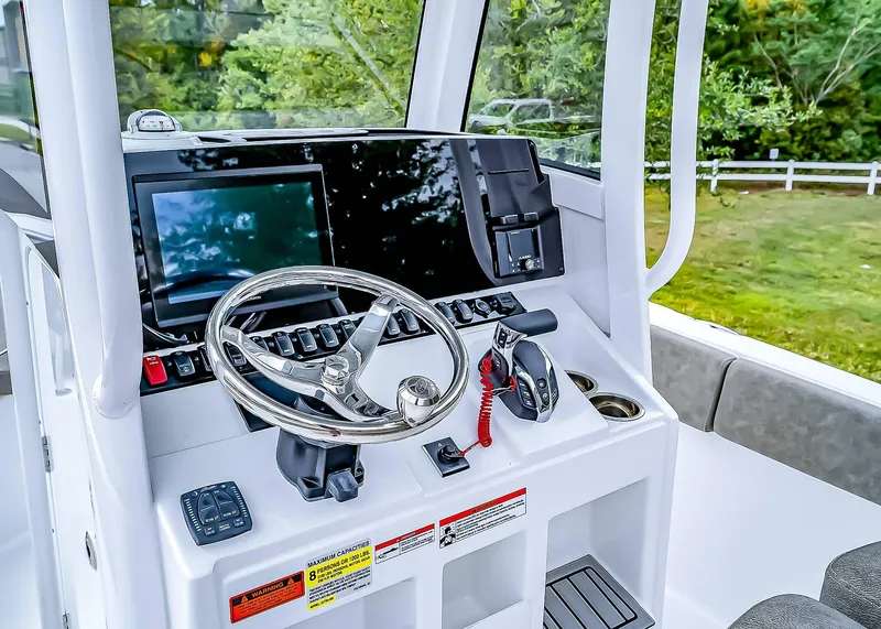 Slide: The Image of 2025 Sea Hunt Ultra 235 SE boat dashboard with steering wheel and controls. - 17