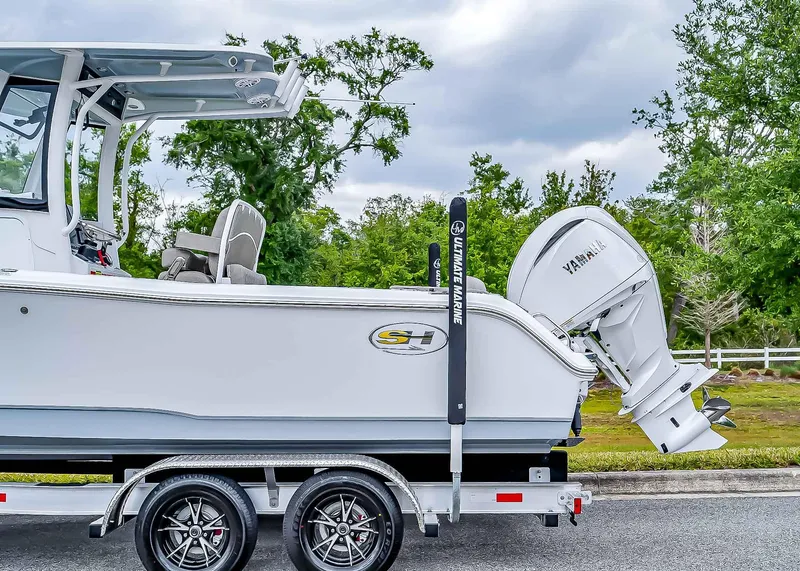 Slide: The Image of 2025 Sea Hunt Ultra 235 SE boat on trailer with Yamaha engine, parked outdoors. - 3
