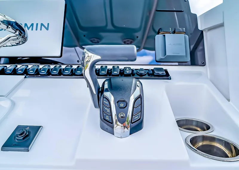 Slide: The Image of Control panel of 2025 Sea Hunt Ultra 245 SE boat with modern throttle and cup holders. - 17
