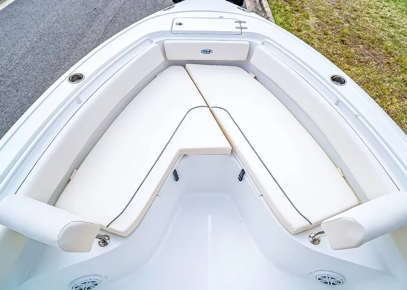 Slide: The Image of 2025 Sea Hunt Ultra 245 SE boat interior with white cushioned seating. - 23