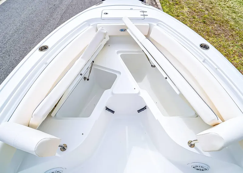 Slide: The Image of 2025 Sea Hunt Ultra 245 SE boat interior with white cushioned seating and storage compartments. - 24