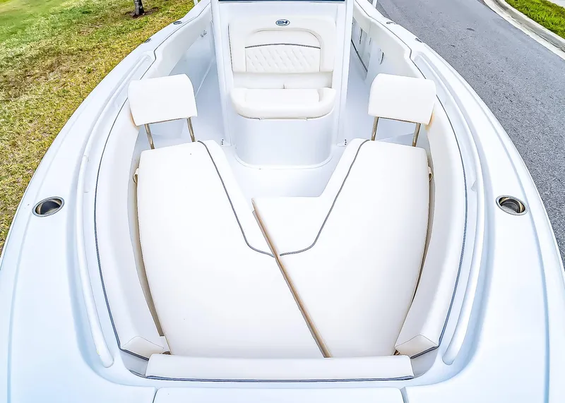 Slide: The Image of 2025 Sea Hunt Ultra 245 SE boat interior with white cushioned seating and sleek design. - 25
