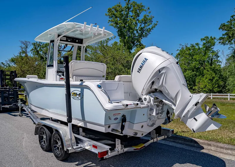 Slide: The Image of 2025 Sea Hunt Ultra 245 SE boat with Yamaha engine on trailer, parked outdoors. - 3