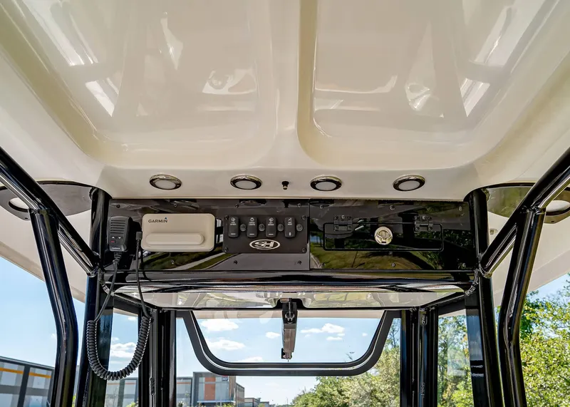 Slide: The Image of 2025 Sea Hunt Ultra 235 SE boat console with Garmin electronics and overhead lighting. - 12