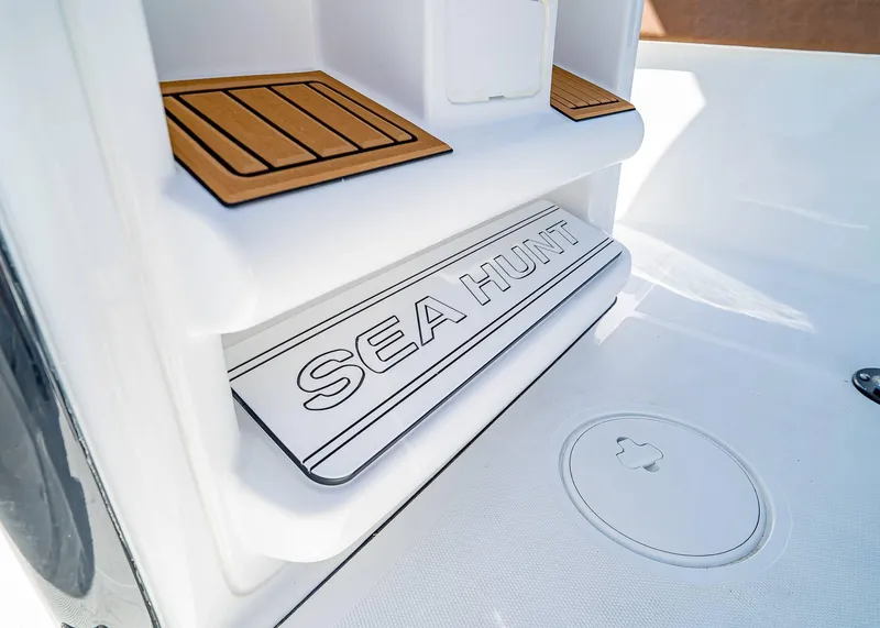 Slide: The Image of 2025 Sea Hunt Ultra 235 SE boat interior with branded step and teak accents. - 15