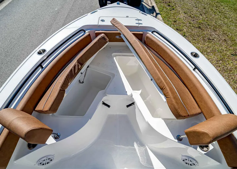 Slide: The Image of 2025 Sea Hunt Ultra 235 SE boat interior with brown cushioned seating and storage compartments. - 22