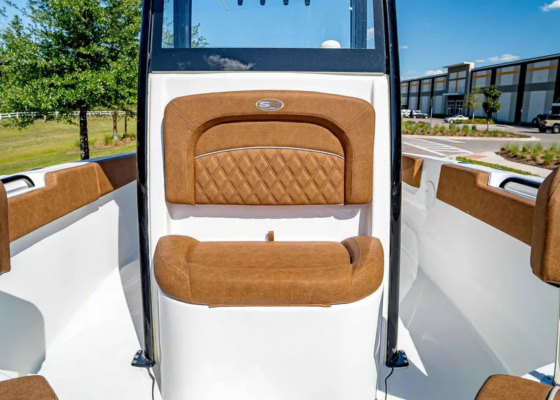 Slide: The Image of 2025 Sea Hunt Ultra 235 SE boat interior with brown cushioned seating. - 23