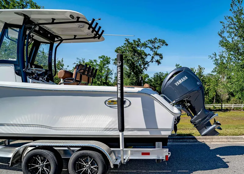 Slide: The Image of 2025 Sea Hunt Ultra 235 SE boat on trailer with Yamaha engine, parked outdoors. - 3