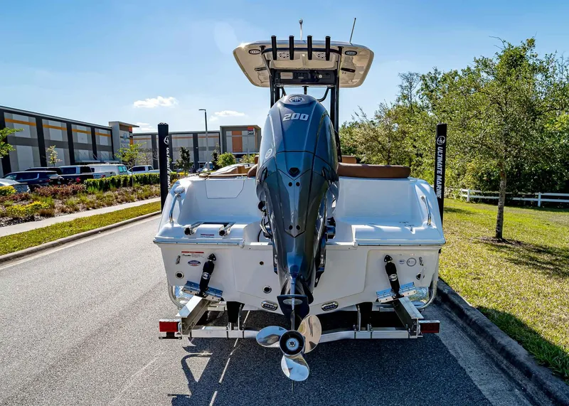 Slide: The Image of 2025 Sea Hunt Ultra 235 SE boat with powerful outboard motor on a sunny day. - 5