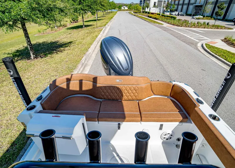 Slide: The Image of 2025 Sea Hunt Ultra 235 SE boat with brown seating, parked on a road. - 6