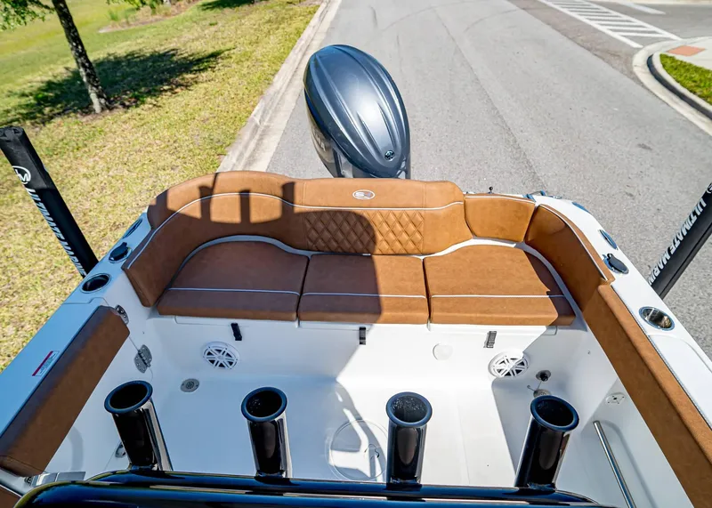 Slide: The Image of 2025 Sea Hunt Ultra 235 SE boat interior with brown seating and rod holders. - 7