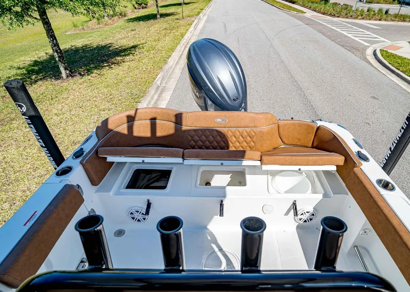 Slide: The Image of 2025 Sea Hunt Ultra 235 SE boat interior with brown seating and fishing rod holders. - 8