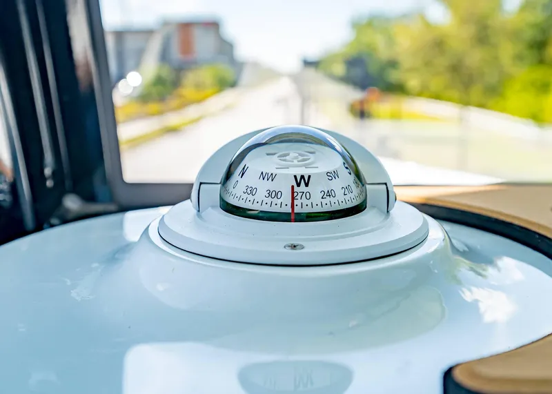 Slide: The Image of Compass on 2025 Sea Hunt Ultra 245 SE boat dashboard, showing west direction. - 12