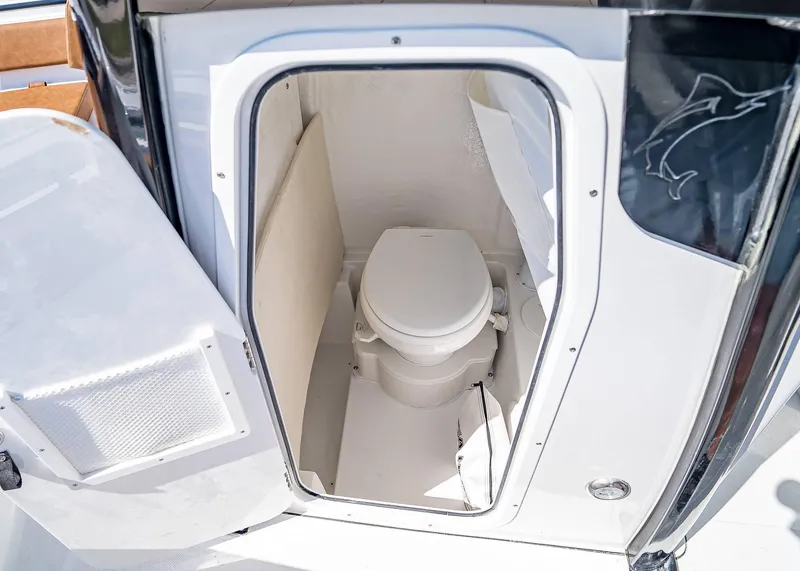 Slide: The Image of 2025 Sea Hunt Ultra 245 SE boat interior with compact marine toilet. - 13