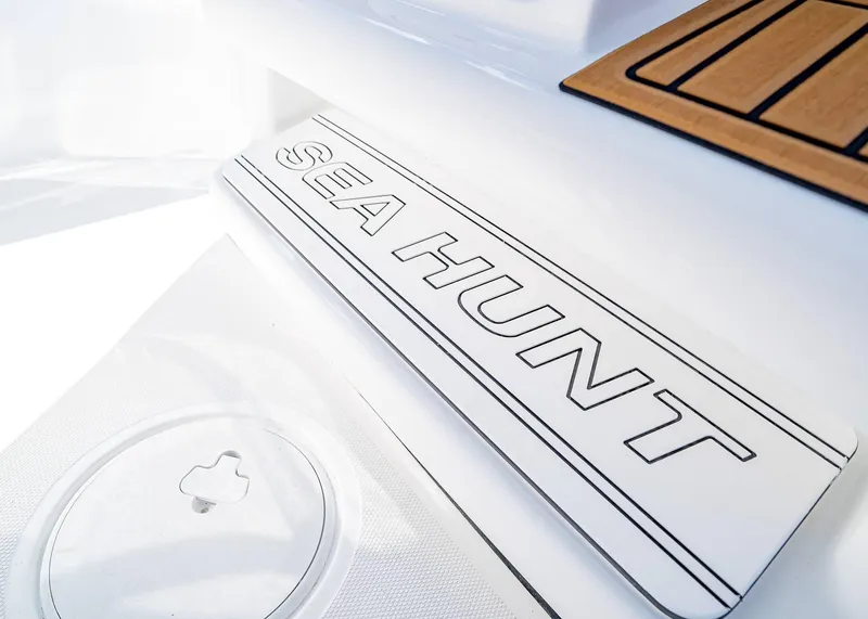 Slide: The Image of 2025 Sea Hunt Ultra 245 SE boat deck with logo and teak accents. - 24