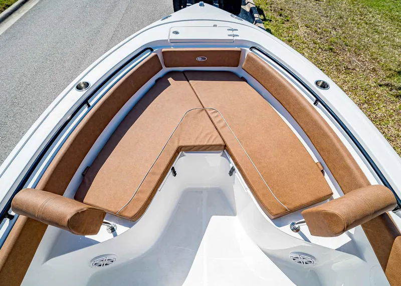 Slide: The Image of 2025 Sea Hunt Ultra 245 SE boat with tan cushioned seating and sleek design. - 26