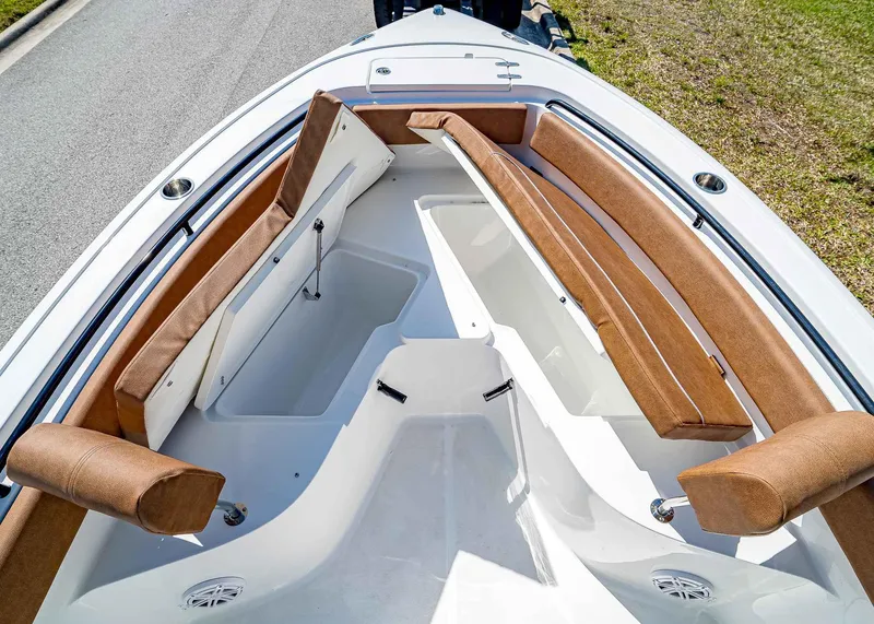 Slide: The Image of 2025 Sea Hunt Ultra 245 SE boat interior with brown cushioned seating and storage compartments. - 27