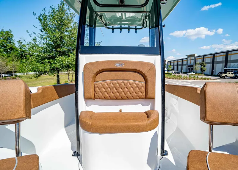 Slide: The Image of 2025 Sea Hunt Ultra 245 SE boat interior with brown cushioned seating. - 29