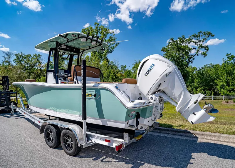 Slide: The Image of 2025 Sea Hunt Ultra 245 SE boat on trailer with Yamaha engine, parked outdoors. - 4