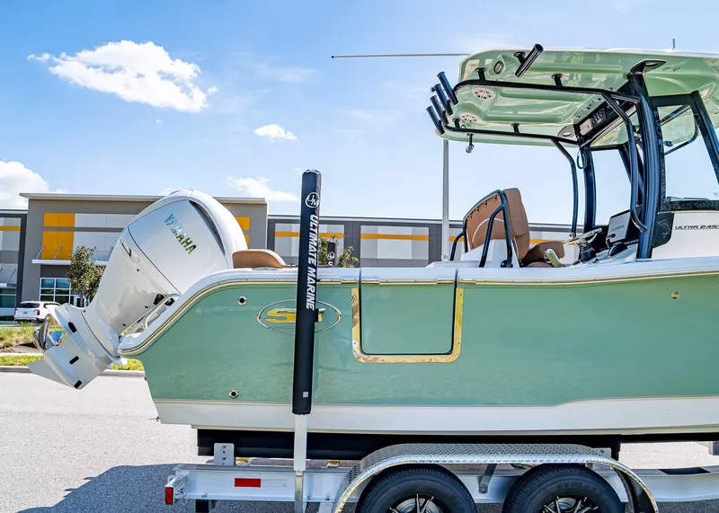 Slide: The Image of 2025 Sea Hunt Ultra 245 SE boat on trailer, featuring Yamaha engine, parked outdoors. - 7