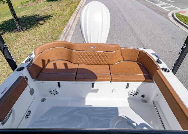 Slide: The Image of 2025 Sea Hunt Ultra 245 SE boat interior with brown cushioned seating and cup holders. - 8